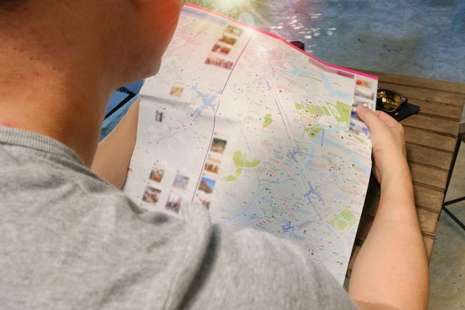 A traveler studying a paper city map outdoors