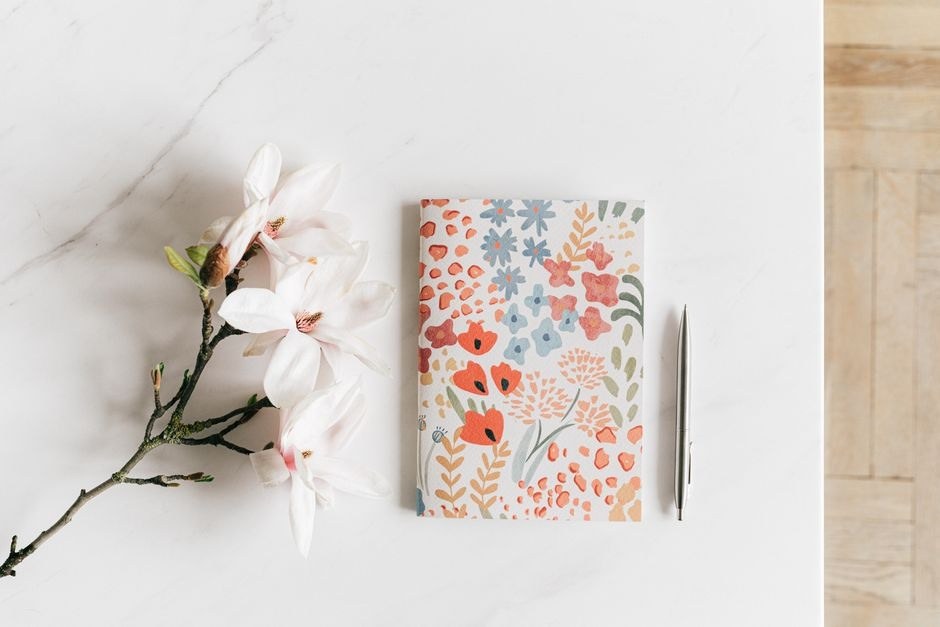 Notebook and magnolia on a bright work table