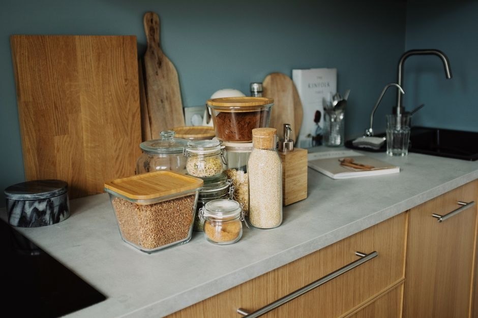 A tidy kitchen counter with jars, boards and everyday cooking tools